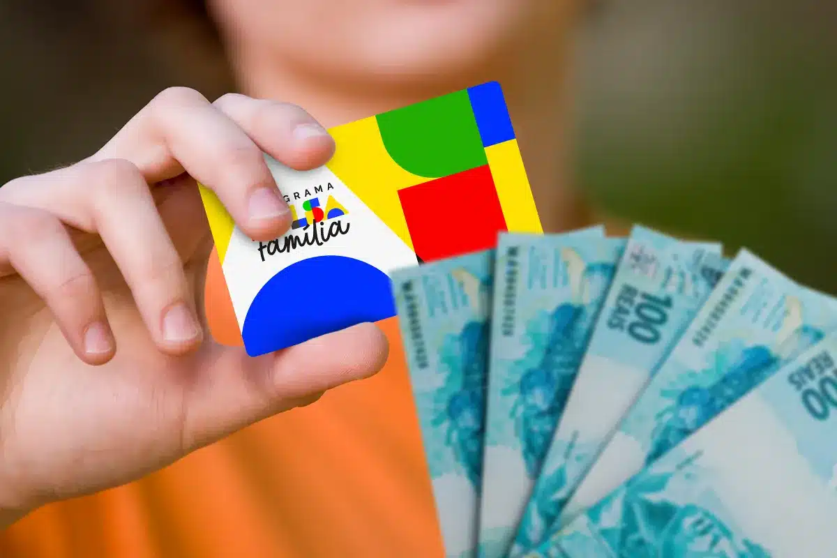 Cartão do Bolsa Família sendo segurado na mão com notas de dinheiro ao lado, representando o pagamento do benefício social.
