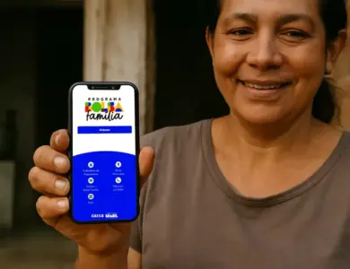 Mulher sorridente exibe celular com tela do app Bolsa Família, mostrando opções de consulta e calendário