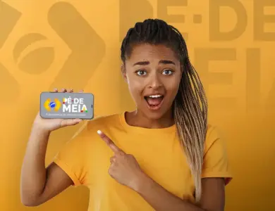 Jovem segurando celular com aplicativo Pé de Meia