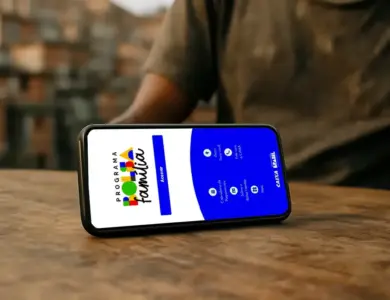 Celular sobre mesa de madeira com a tela do aplicativo Bolsa Família